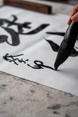 An old Chinese calligrapher is creating and writing calligraphy works.
Translation: carry on the...