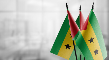 Small flags of the Sao Tome and Principe on an abstract blurry background