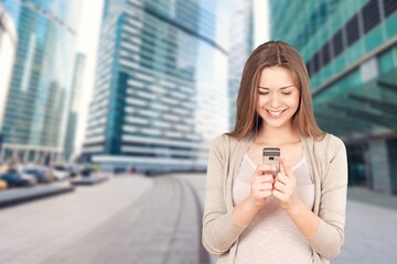 Fototapeta premium Young adult professional business woman holding smartphone