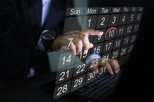 A businessman pointing to calendar on virtual screen to plan work and set team goals or mile stone.