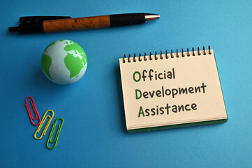 There is a notebook with the word Official Development Assistance. It is eye-catching image.