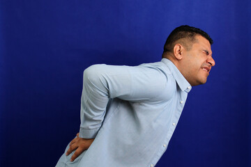 Dark-haired Latino adult man with neck, back and waist pain from trauma, injury or fracture
