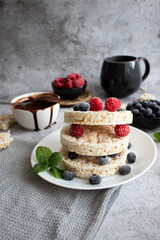 Rice cakes with berries and chocolate. Deliciously. A snack On a gray background