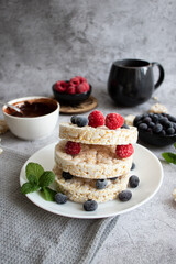 Rice cakes with berries and chocolate. Deliciously. A snack On a gray background