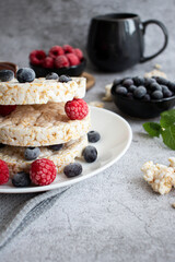 Rice cakes with berries and chocolate. Deliciously. A snack On a gray background