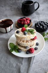Rice cakes with berries and chocolate. Deliciously. A snack On a gray background