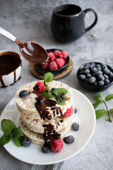Rice cakes with berries and chocolate. Deliciously. A snack On a gray background