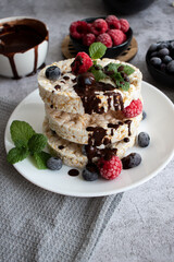 Rice cakes with berries and chocolate. Deliciously. A snack On a gray background