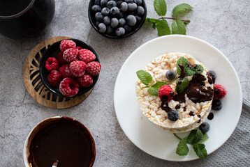 Rice cakes with berries and chocolate. Deliciously. A snack On a gray background