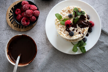Fototapeta na wymiar Rice cakes with berries and chocolate. Deliciously. A snack On a gray background