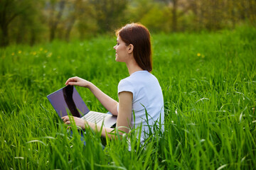 Naklejka na ściany i meble Business woman relaxing in green grass field outdoor under sun. Bright sunny day