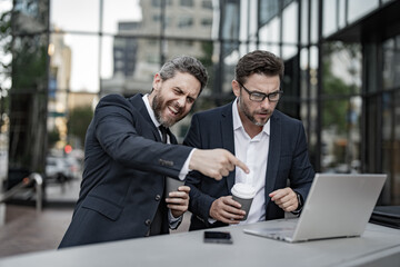 glad trader men freelancing online outdoor. trader business men freelancing online with laptop.