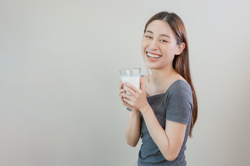 Happy asian women holding glass fresh milk. Healthy food concept. Drinks beneficial to body. Female enjoy drinking calcium lactose. Copy space use for text message.