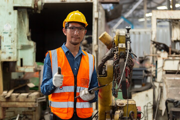 asian engineering worker man wearing uniform safety and hardhat working machine lathe metal in factory industrial, worker manufactory industry concept. repair serviceman at workshop.