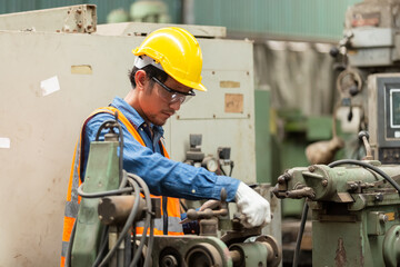 asian engineering worker man wearing uniform safety and hardhat working machine lathe metal in factory industrial, worker manufactory industry concept. repair serviceman at workshop