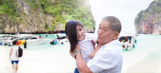 Happiness travel with Grandfather holding granddaughter to travel to the ocean beach during school...
