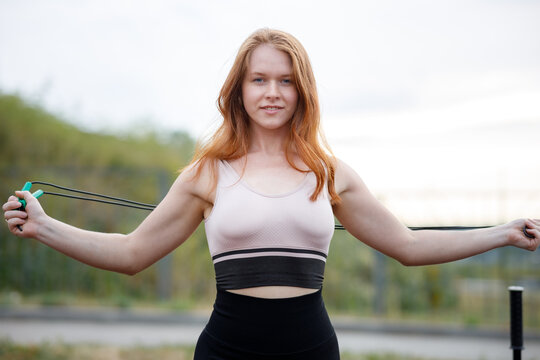 The Girl Spread Her Arms In Different Directions Holding A Skipping Rope Outdoors On A Summer Evening