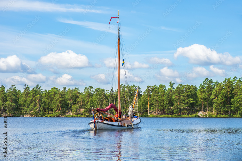 Sticker Wooden sailboat on a beautiful lake by a forest