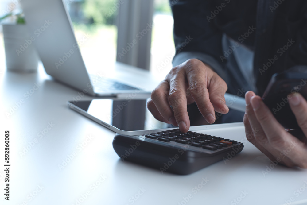 Poster business man using calculator to calculate business report, e-document on mobile phone and digital t