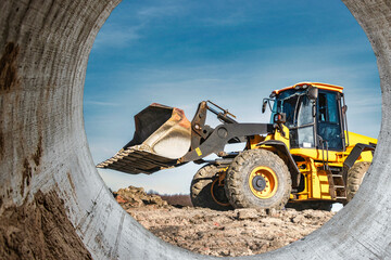 Powerful wheel loader or bulldozer working on a quarry or construction site. Earthworks in...