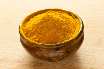 Curcuma powder in wooden bowl