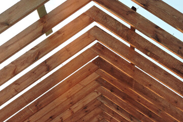 A timber roof truss of a house under construction - obrazy, fototapety, plakaty