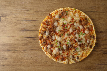 Vegetarian fresh baked crusty pizza with champignons, tomatoes, green onion and mozzarella on wooden background.