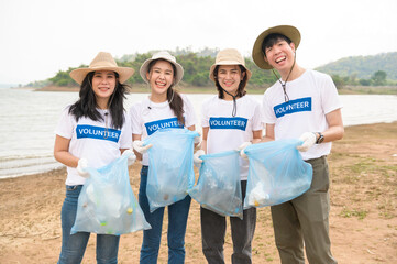 Volunteers from the Asian youth community using rubbish bags cleaning  up nature par