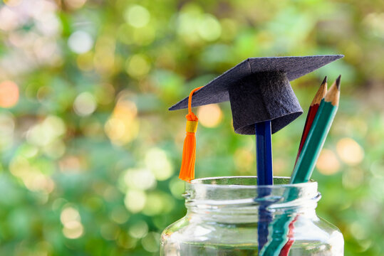 Back to school or graduate certificate program concept : Black graduation cap and a pencil in a bottle. Back to school is the period in which students prepares school supply for upcoming school year.
