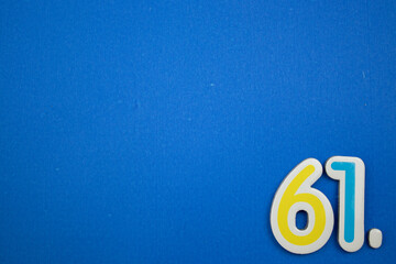 61. number of. Placed on the edge of the blue background, photographed from above.
