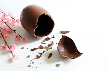 Uovo di cioccolato rotto e intero isolato su sfondo bianco. Carta di Pasqua. Avvicinamento.