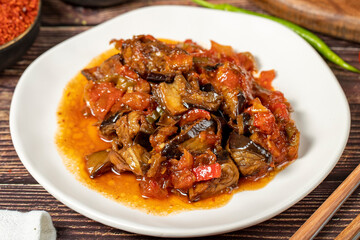 Eggplant dish with vegetables fried in olive oil on a wooden floor. Close up