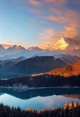 Sunset over Snowy Mountains and Tranquil Lake Reflection
