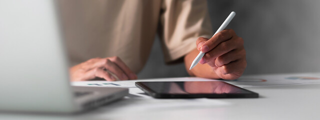 Close up of student hand using electronic pen with tablet. education e-learning concept for banner