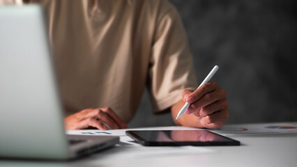 Close up of student hand using electronic pen with tablet. education e-learning concept