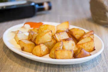 Papas bravas, are a typical preparation of bars in Spain consisting of potatoes cut into large cubes, fried in olive oil and seasoned with salsa brava, which is a spicy sauce.