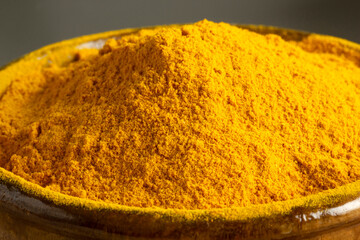 Curcuma powder in wooden bowl