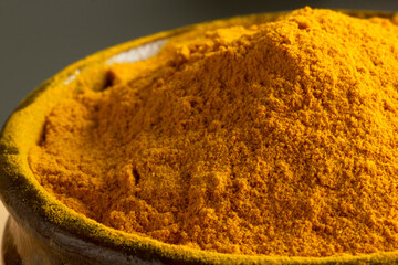 Curcuma powder in wooden bowl