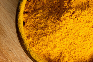 Curcuma powder in wooden bowl