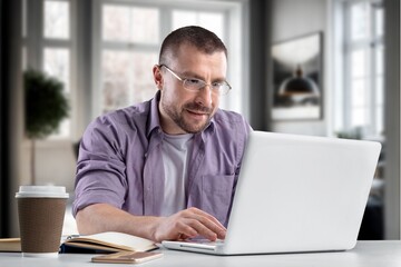 Fototapeta premium Cheerful male working on computer at home.