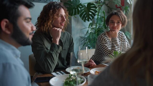 Multinational pensive friends talking at birthday party in cafe