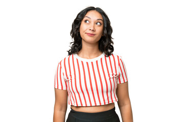 Young Argentinian woman over isolated background and looking up