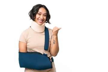 Young argentinian woman wearing neck brace and sling over isolated background pointing to the side to present a product