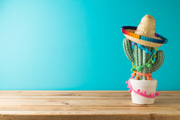 Mexican table decoration with cactus and sombrero hat  over blue background. Cinco de Mayo holiday...