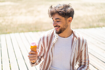 Handsome Arab man with a cornet ice cream at outdoors with happy expression