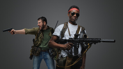 Studio shot of black macho man and violent man survivors in post apocalyptic setting.