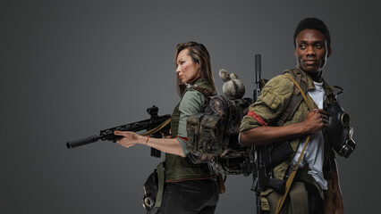 Shot of black man and white woman with rifles isolated on grey background.