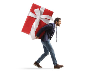 Full length profile shot of a man carrying a big gift box on his back