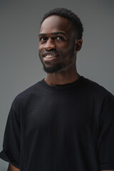 Studio shot of smiling black man with stylish hairstyle dressed in t shirt.