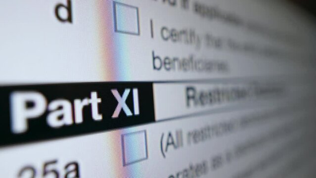 W-8BEN-E Tax form. Digital version of document on monitor screen scrolling in close-up